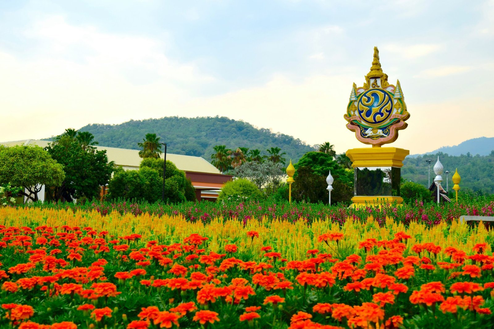 a field of flowers with a statue in the background